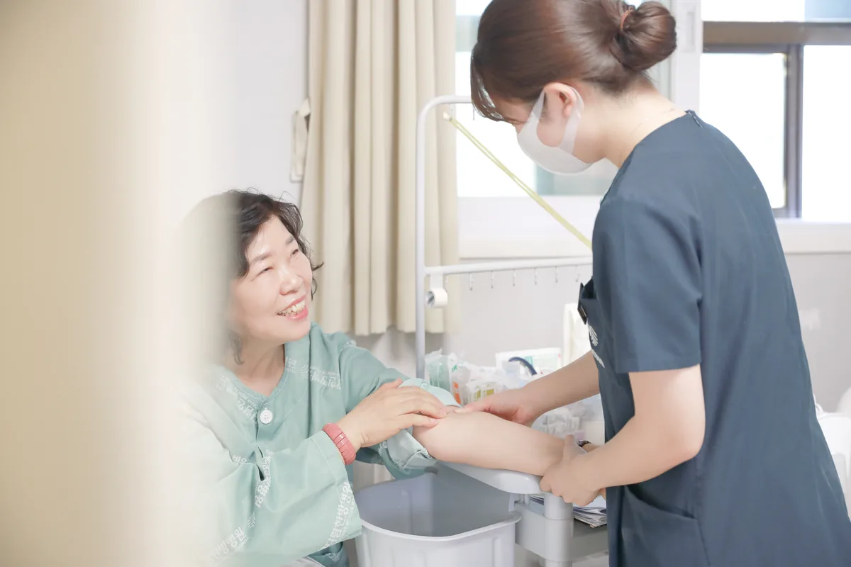 간호사가 입원 환자의 상태를 살피며 처치를 준비하는 모습