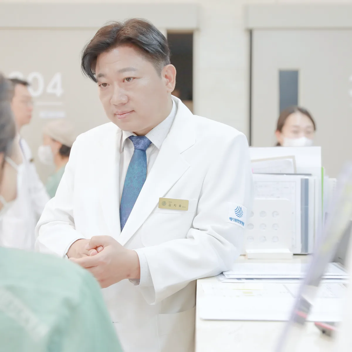 간호사실 앞에서 원장이 부인암 수술 뒤 입원한 환자의 회복 상태 이야기를 듣고 있는 모습