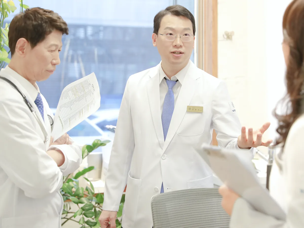 두 원장이 환자의 혈액검사 결과지를 들고 신장 기능 수치를 함께 확인하며 상의하는 장면