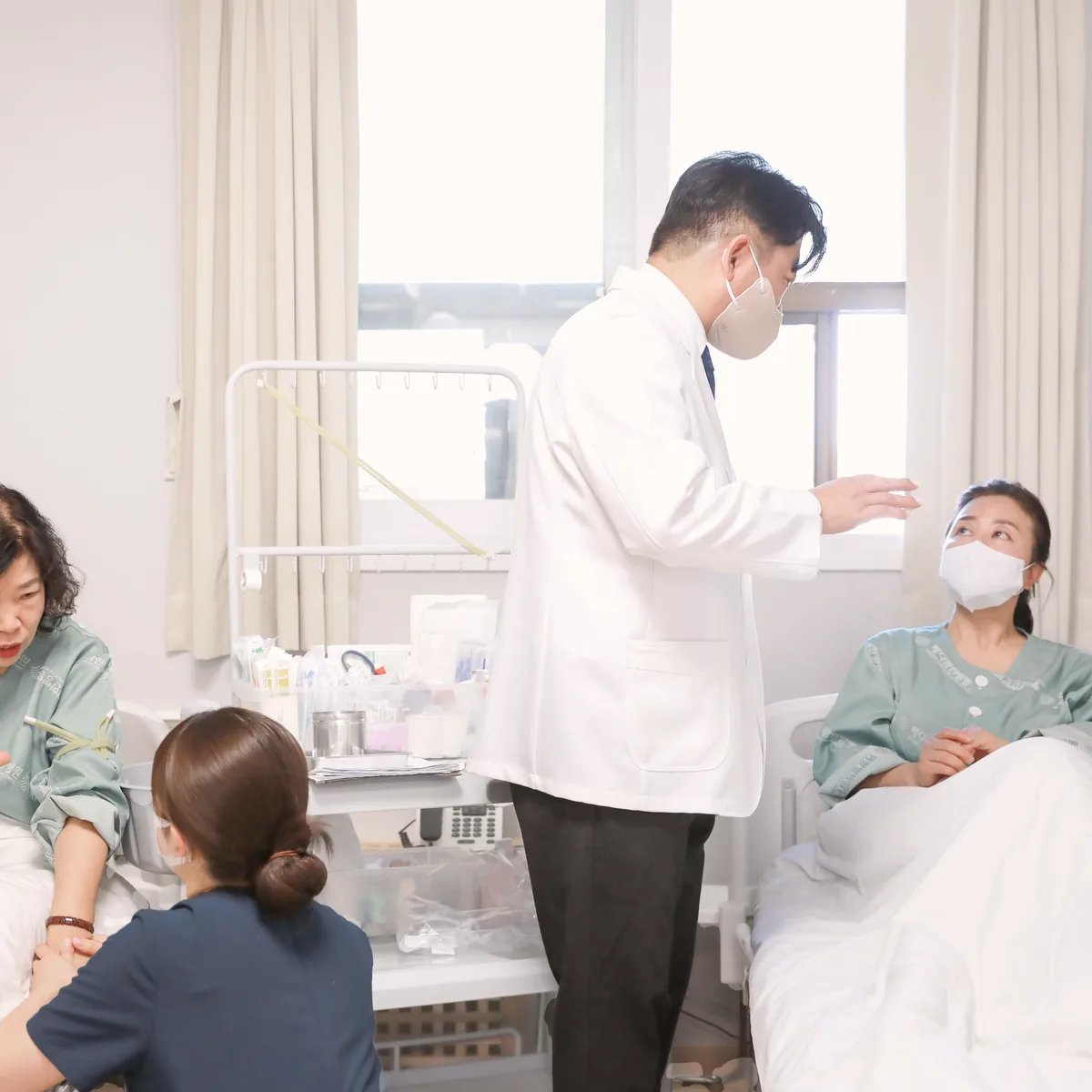 항암치료 기간 중 입원한 환자의 병상을 찾아 의료진과 간호사가 상태를 살피는 회진 장면