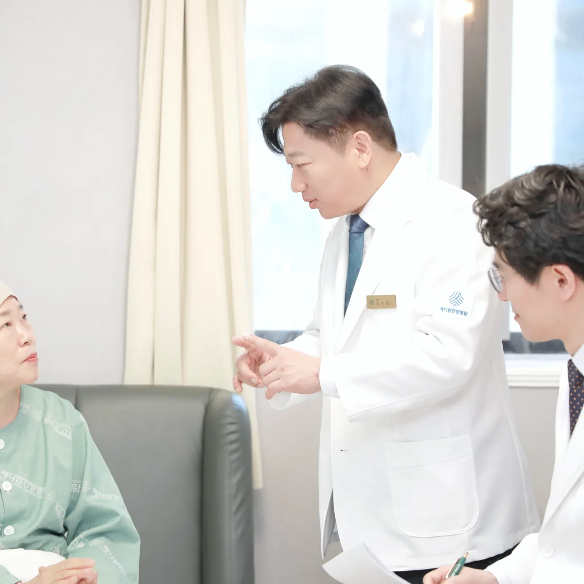 병실 앞 상담 공간에서 원장이 회복 중인 환자에게 식사 뒤 자세와 생활 습관을 설명하는 모습
