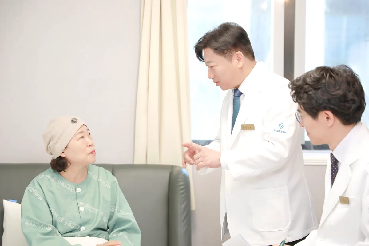 병실 소파에 앉은 환자에게 원장이 손짓으로 설명하고 다른 의료진이 옆에서 함께 듣는 상담 장면