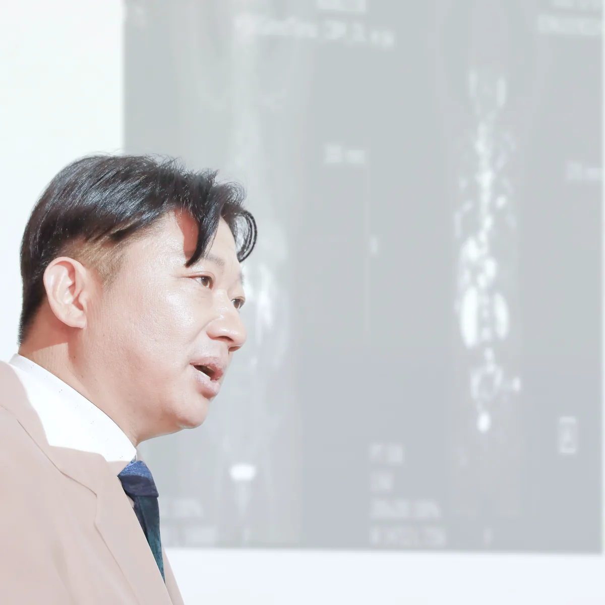 원장이 화면에 띄운 전신 영상 앞에서 병변이 있는 위치와 범위를 설명하는 모습