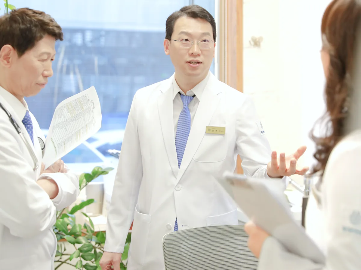 원장이 병동에서 간호사와 함께 환자의 통증 경과와 치료 계획을 이야기하는 모습