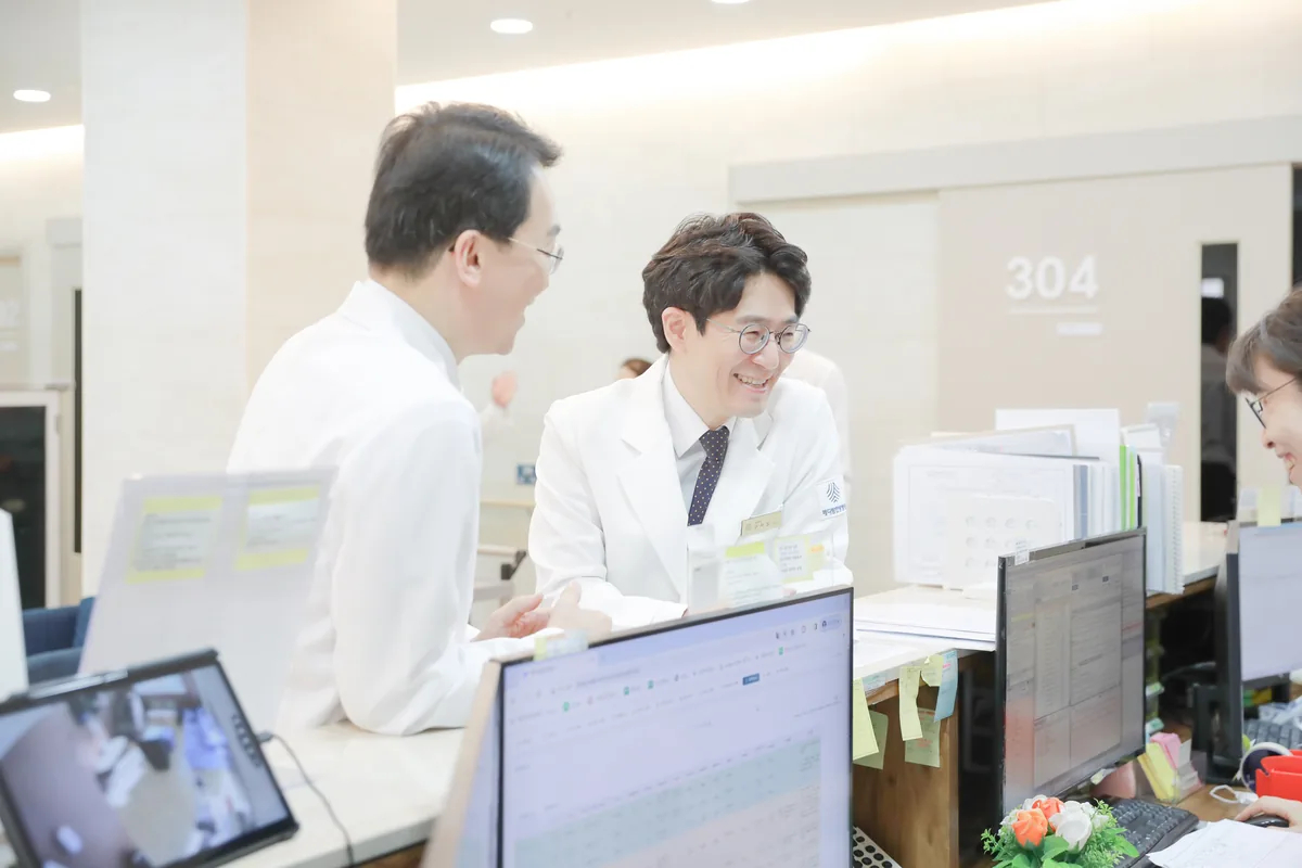 의료진이 간호사실에서 환자의 치료 일정과 검사 결과를 함께 확인하는 모습
